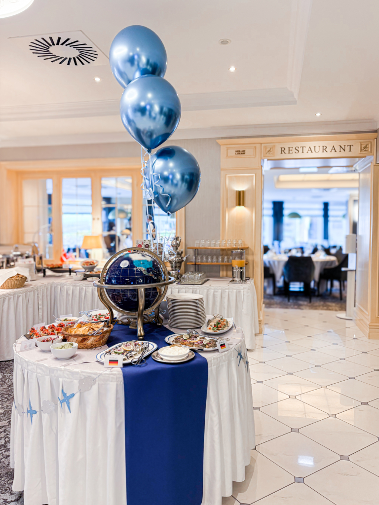 Eleganter Tisch mit Buffetauswahl und blauen Luftballons in einem Restaurant